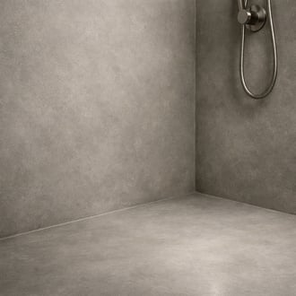 Closeup of a microcement shower wall and floor showing very subtle texture and seamless transitions Warm gray tones with soft lighting highlighting th-1